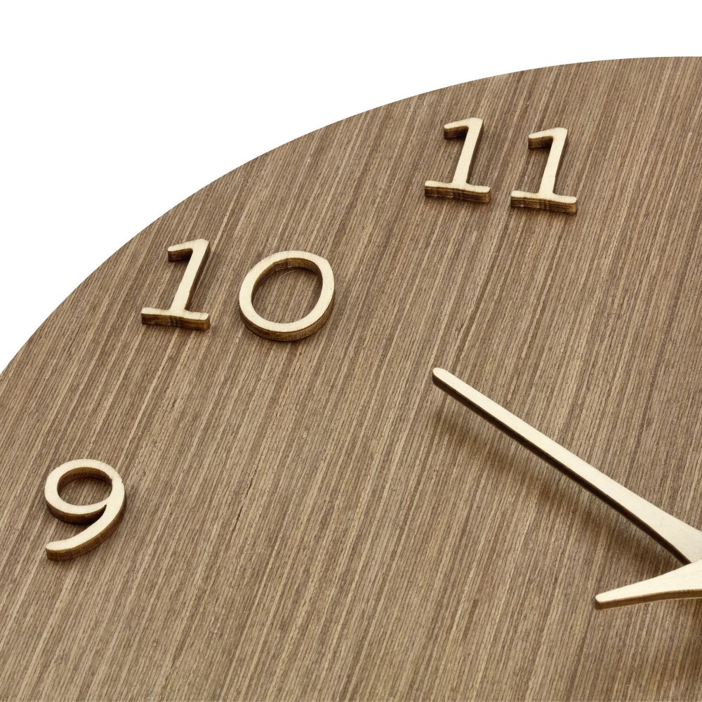 Dřevěné hodiny na zeď, detail korpusu, číslic a ručiček zblízka.